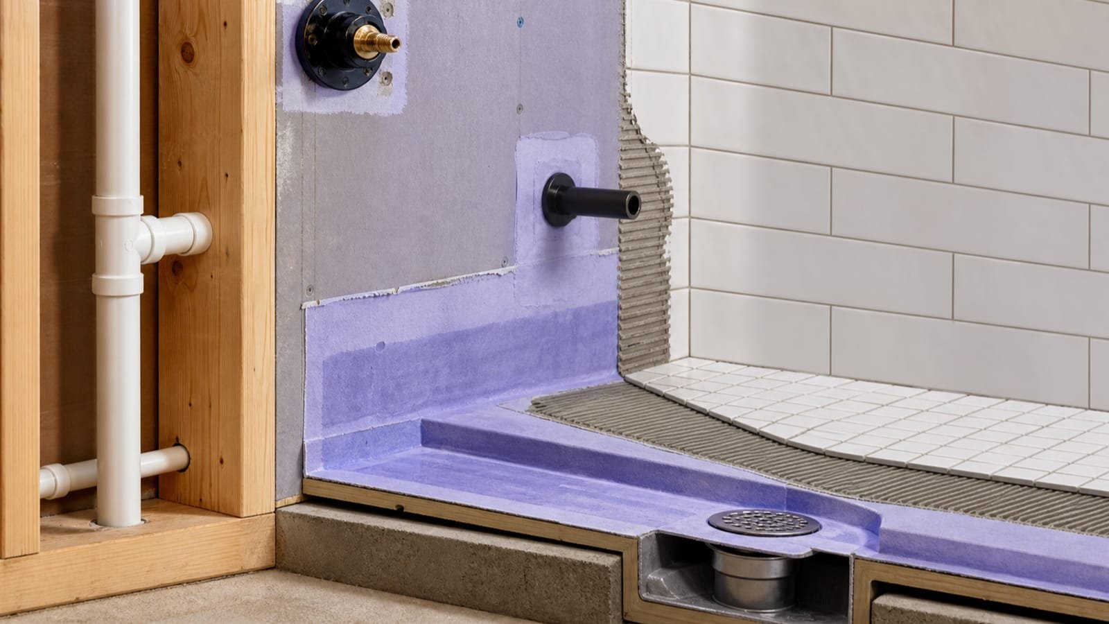 Shower cutaway showing framing, drain, waterproofing, setting bed, and tile layers
